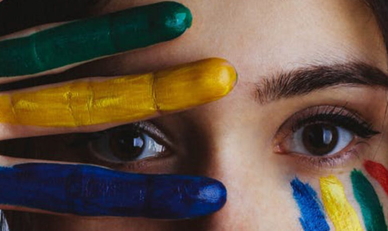 vrouwen ogen met vingers in groen geel blauwvoor gezicht